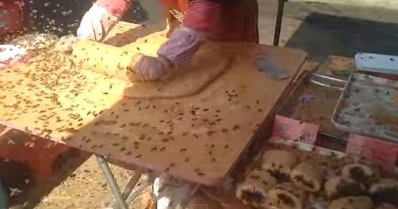 中国 無数のハチに囲まれながらも余裕でお菓子を作るオバチャンの屋台が凄まじい ロケットニュース24